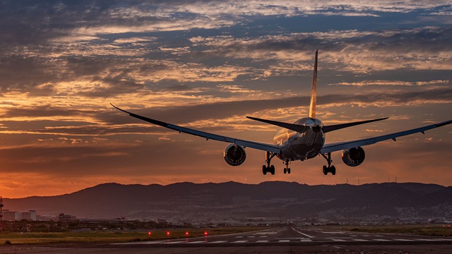 back view airplane landing sunset