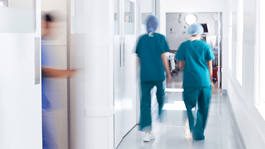 Two doctors walking down the hallway of a hospital. 