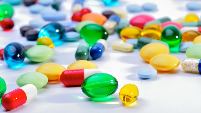 Multi-coloured pills on a counter 